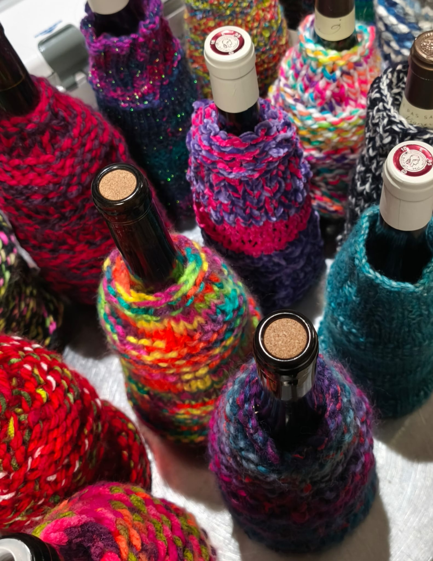 Bouteilles habillées de chaussettes colorées tricotées main, signature de Chaussette